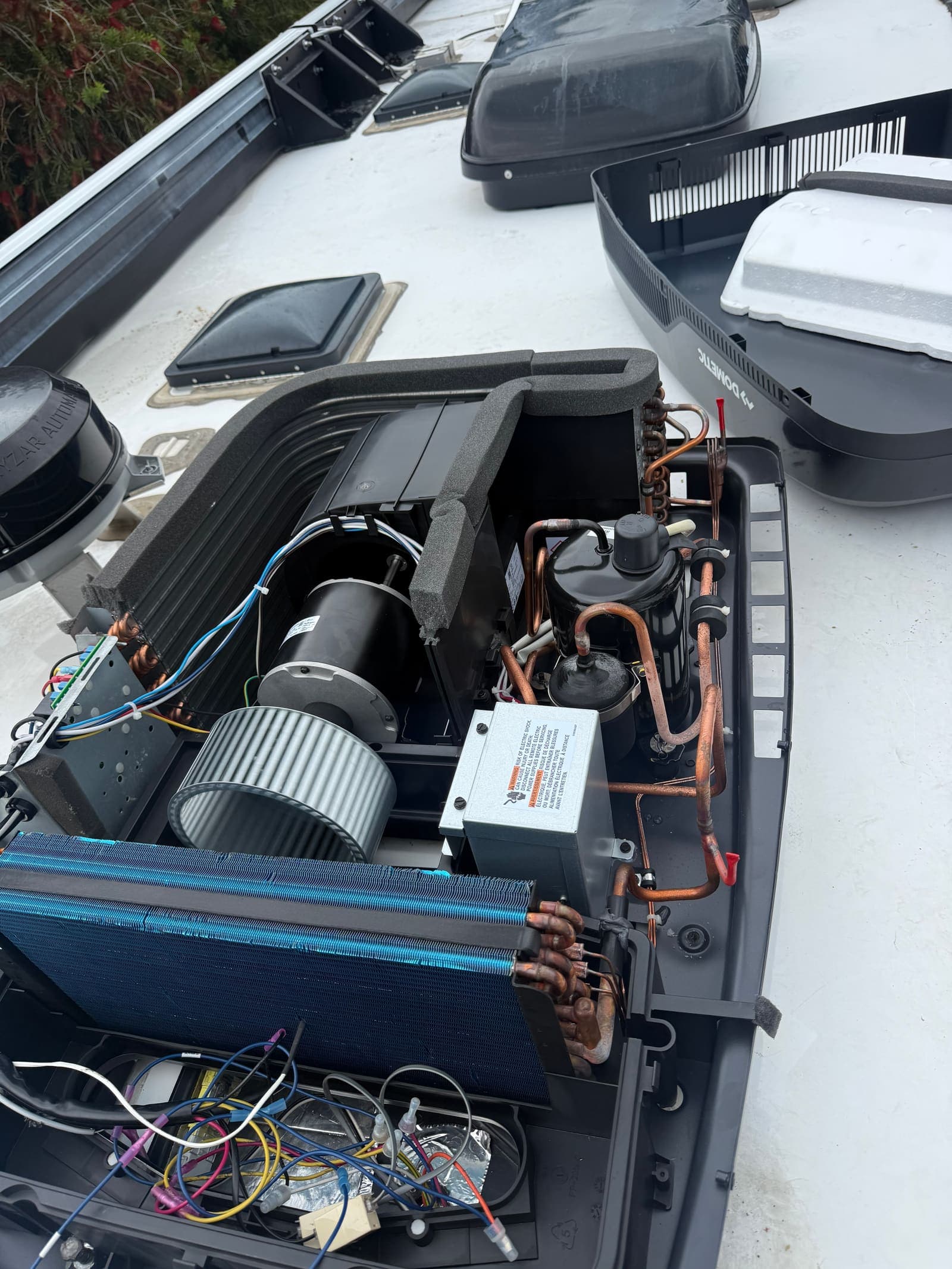 Dometic rooftop A/C unit with cover removed during mobile repair