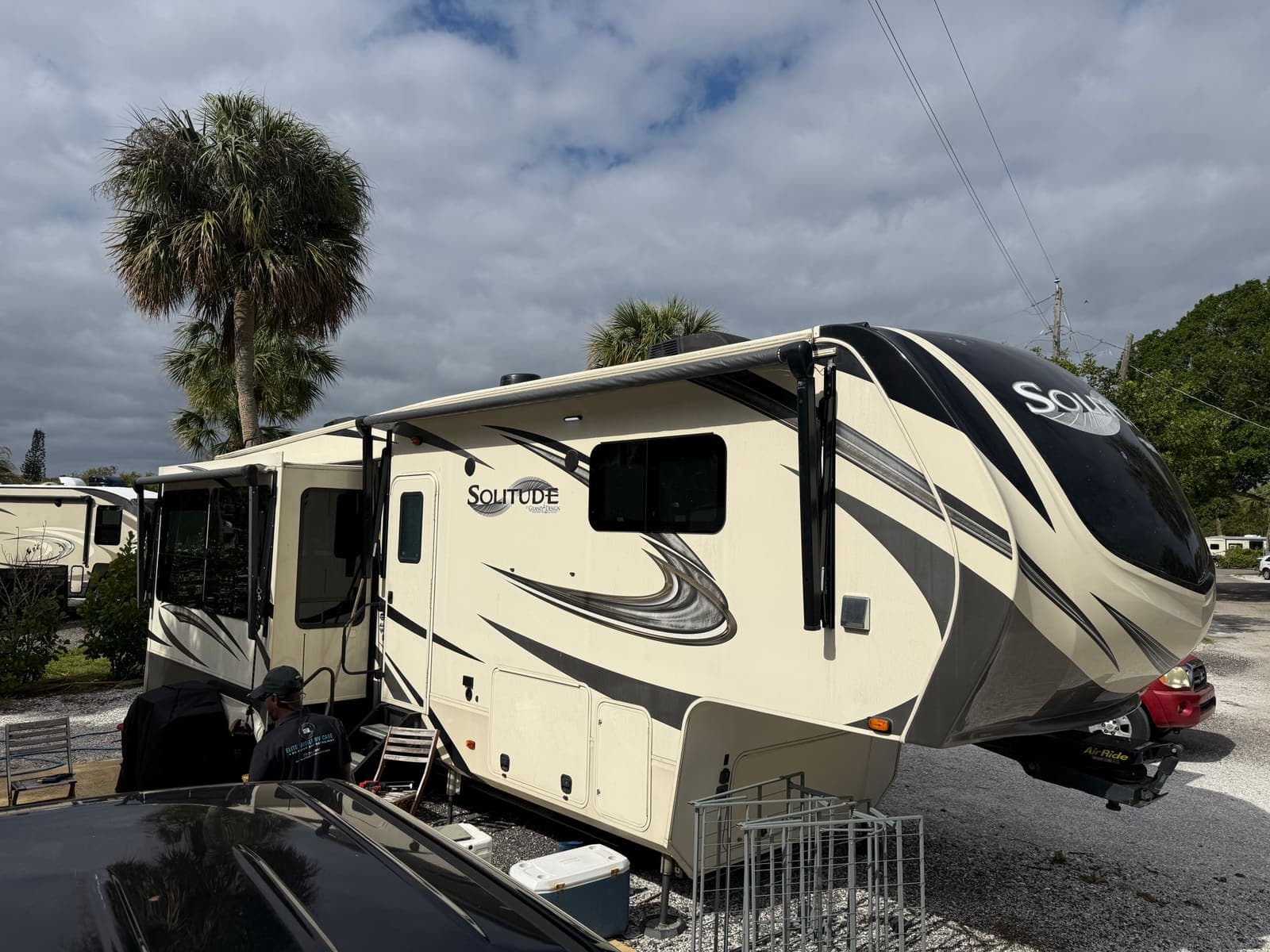 Alex from Elite Mobile RV Care working on a Grand Design Solitude fifth-wheel RV at a Treasure Coast jobsite